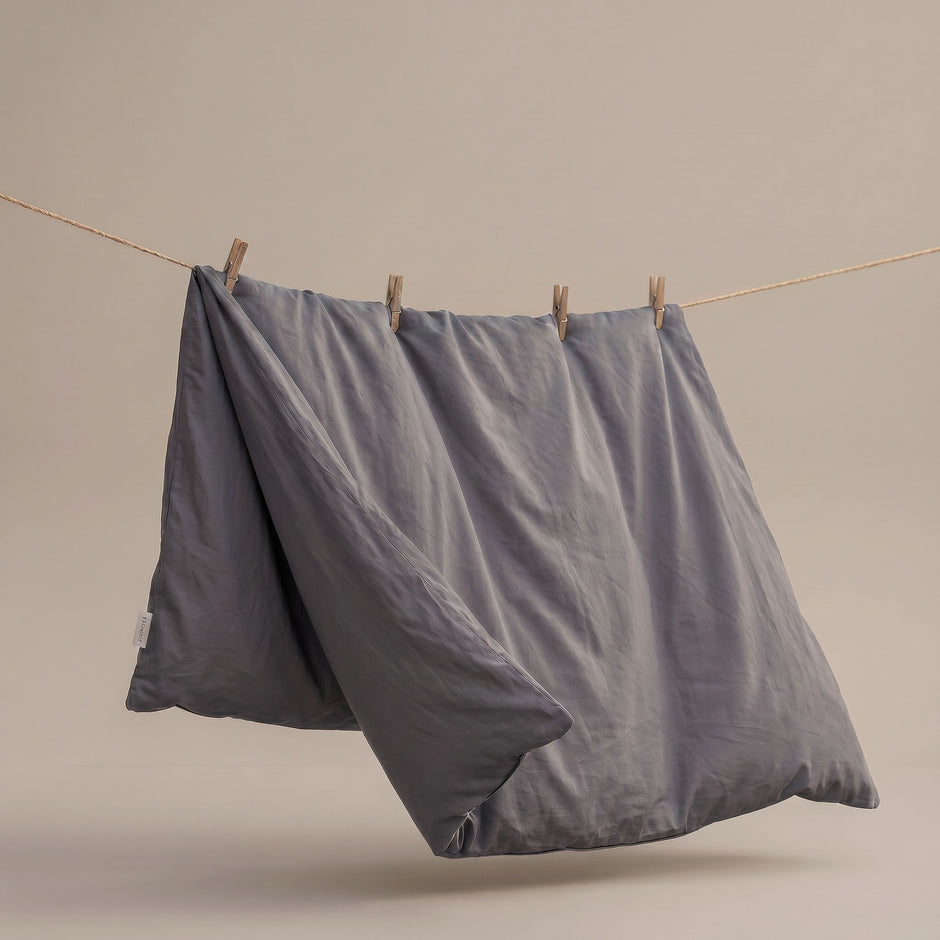 Plumelle waschbare Bettdecke in Warm Grey zum Lufttrocknen an einer Leine aufgehängt, nahtlose 100% Baumwolle Konstruktion für schnelles Trocknen.