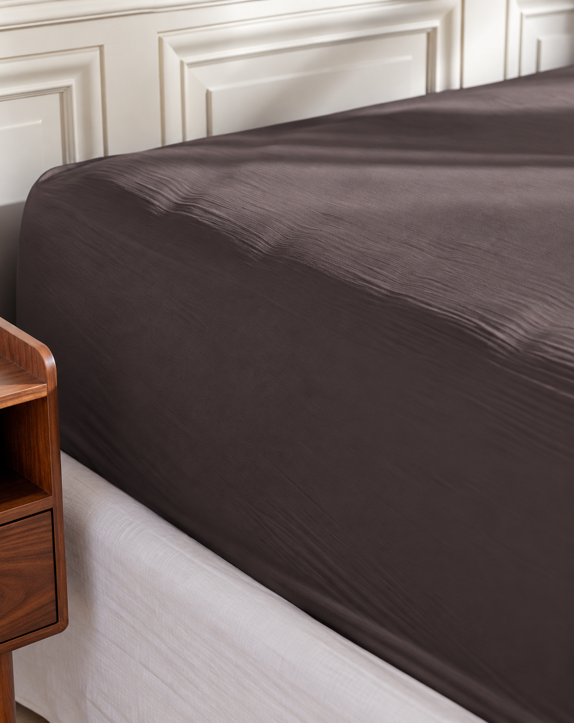 Plumelle Earth Fitted Sheet in Charcoal on a made bed